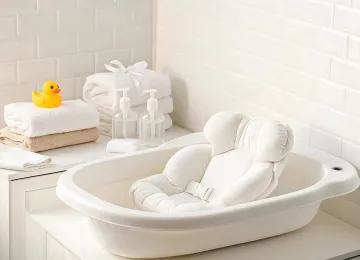 Baby bath seat beside folded towels
